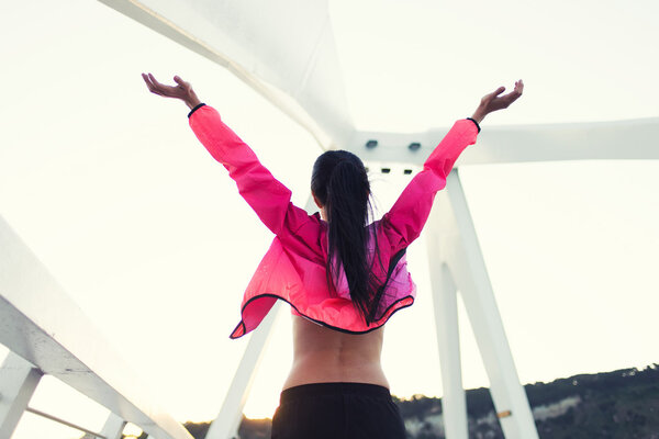 Sportswoman raised hands with feeling of freedom