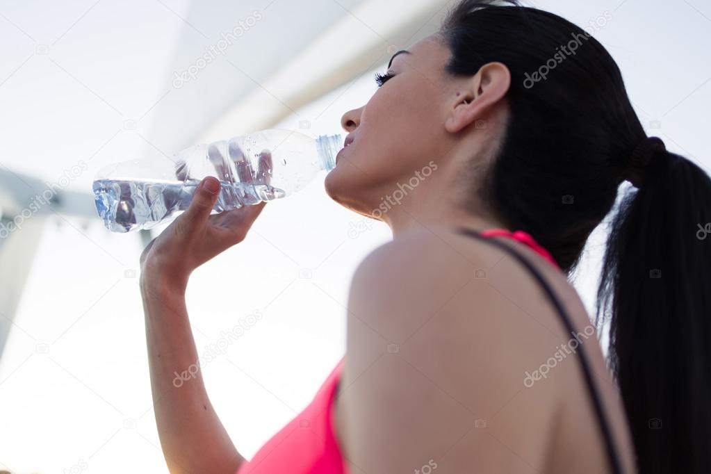 Woman refreshing with energy drink after jog