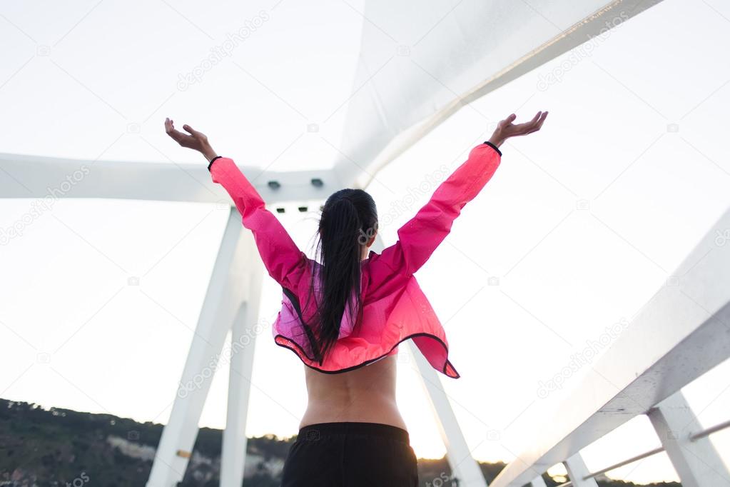 Sportswoman raised hands with feeling of freedom