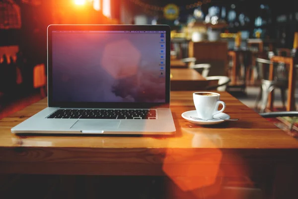 Open net-book and cup of cappuccino — Stok fotoğraf