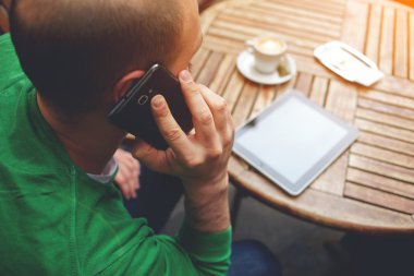 Genç adam cep telefonuyla konuşuyor.