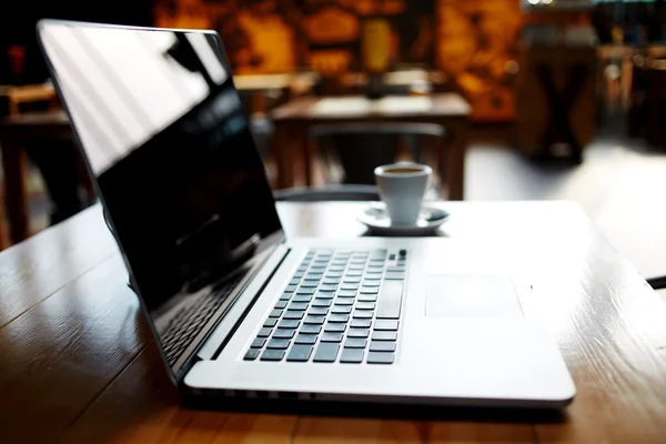 Opengeklapte laptopcomputer op een houten tafel — Stockfoto