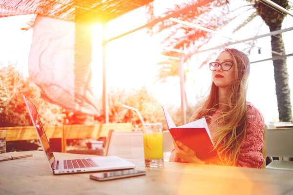 Young woman reading book in cafe