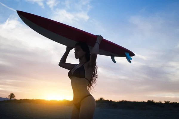 Junge Frau posiert im Bikini mit Surfbrett — Stockfoto