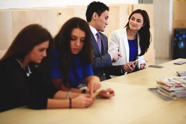 Grupo de jóvenes usando el teléfono inteligente — Foto de Stock