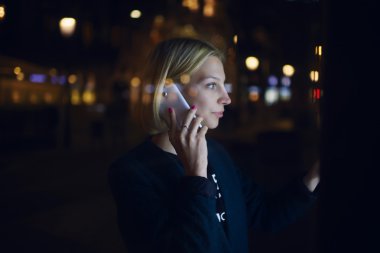 Woman touching digital display on bus stop