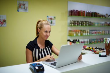 Young working on net-book in cosmetic store
