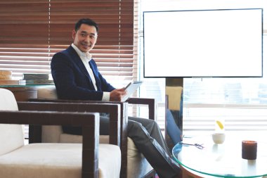 Businessman sitting near blank tv screen
