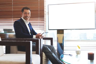 Businessman sitting near blank tv screen