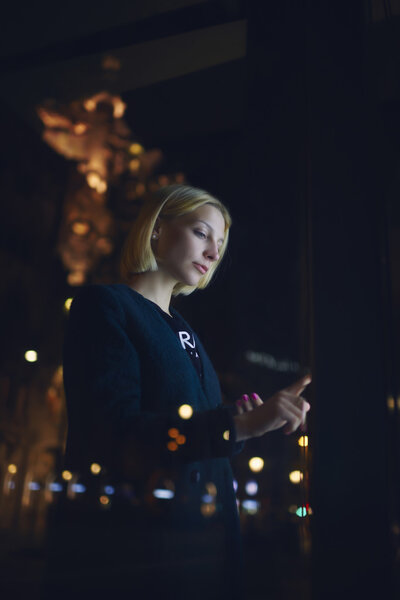 Woman touching digital display on bus stop