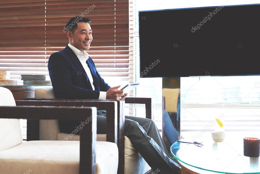 Businessman sitting near blank tv screen