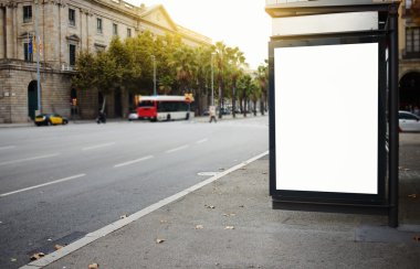 Illuminated blank billboard in urban setting clipart