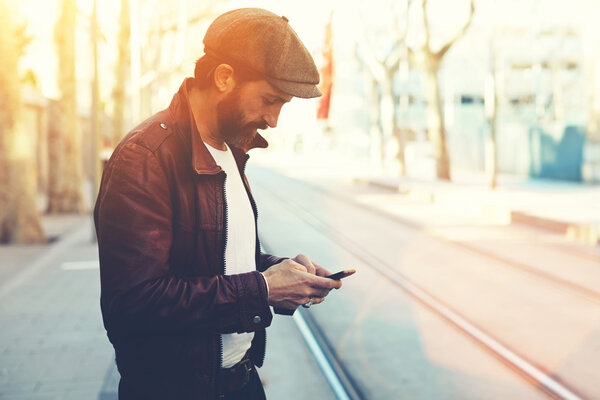 Человек с мобильным телефоном в городской обстановке
