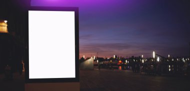 Illuminated blank billboard in night city