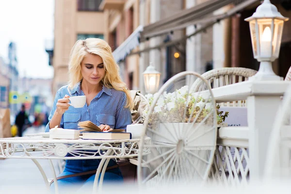 Mulher lendo livro enquanto sentado no café — Fotografia de Stock