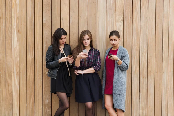 Três mulheres conversando em telefones celulares — Fotografia de Stock