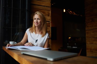 Charming young woman viewing magazine