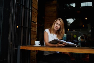 Young woman sitting with magazine