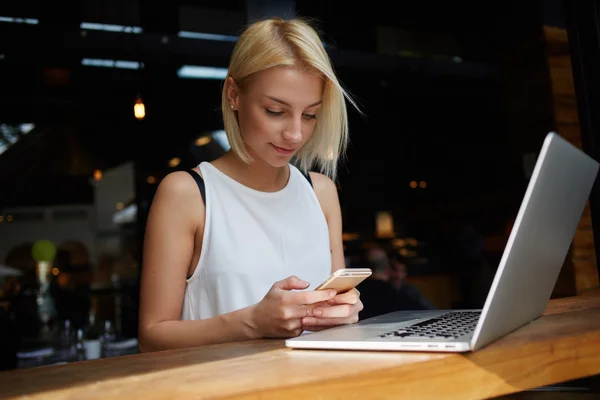 Blonde female using smart phone — 图库照片