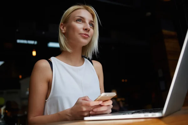 Blonde female holding mobile phone — Stockfoto