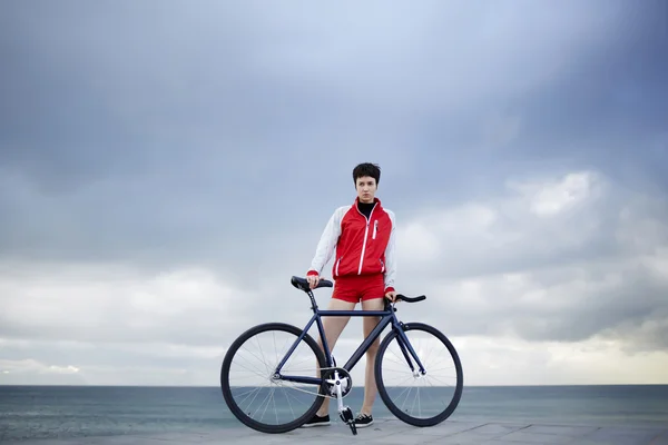 Hipster flicka på stranden med hennes cykel — Stockfoto