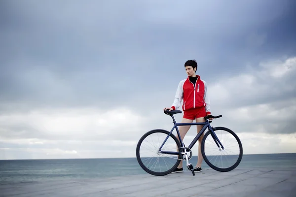 Hipster flicka på stranden med hennes cykel — Stockfoto