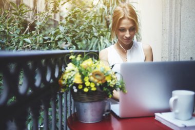 Woman working on laptop computer at balcony
