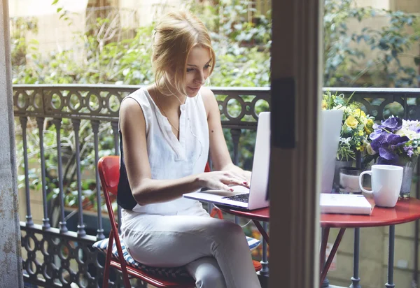 Woman working on laptop computer at balcony — Stock Photo, Image