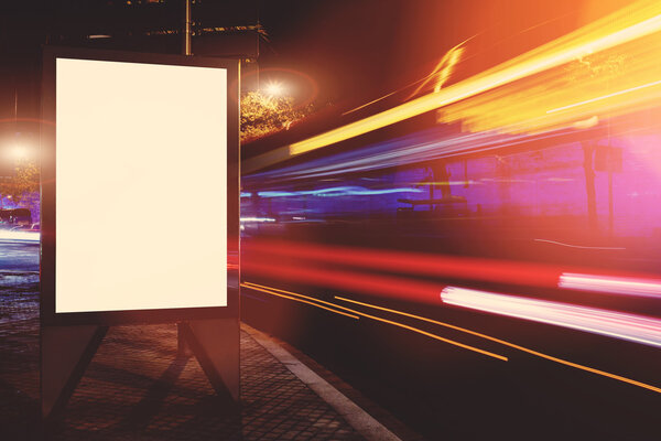 Empty electronic billboard with copy space for your text message or promotional content, public information board in the big city at night, advertising mock up with movement of cars on the background