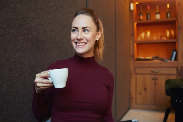 Счастливая женщина наслаждается чашкой кофе — стоковое фото