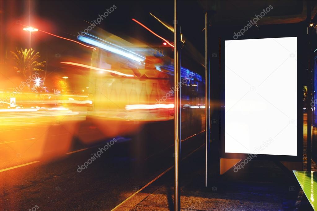 Electronic blank billboard with copy space for your text message or promotional content, clear public information board in night city with cars's movement on background, bus stop advertising mock up