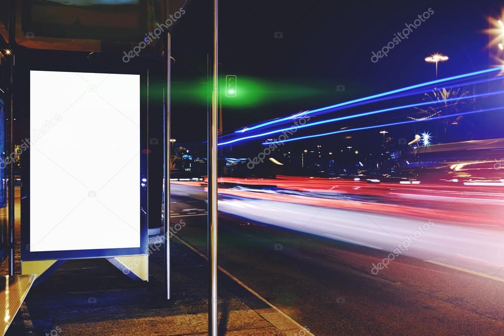 Electronic blank billboard with copy space for your text message or content, public information board with night lights on background, advertising mock up in urban setting, empty Lightbox on bus stop