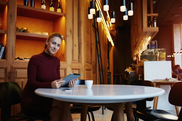 Jeune femme assise avec tablette numérique — Photo