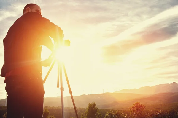 Geodesista homem usando teodolita — Fotografia de Stock