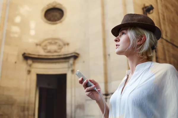 Женщина турист держит мобильный телефон — стоковое фото