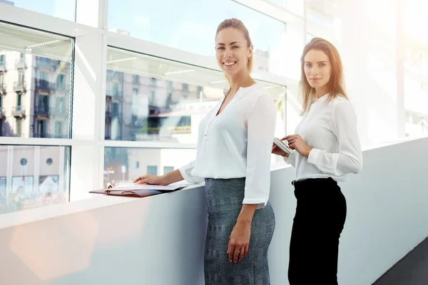 Vrouwelijke ondernemers poseren in de buurt van loket binnenshuis — Stockfoto