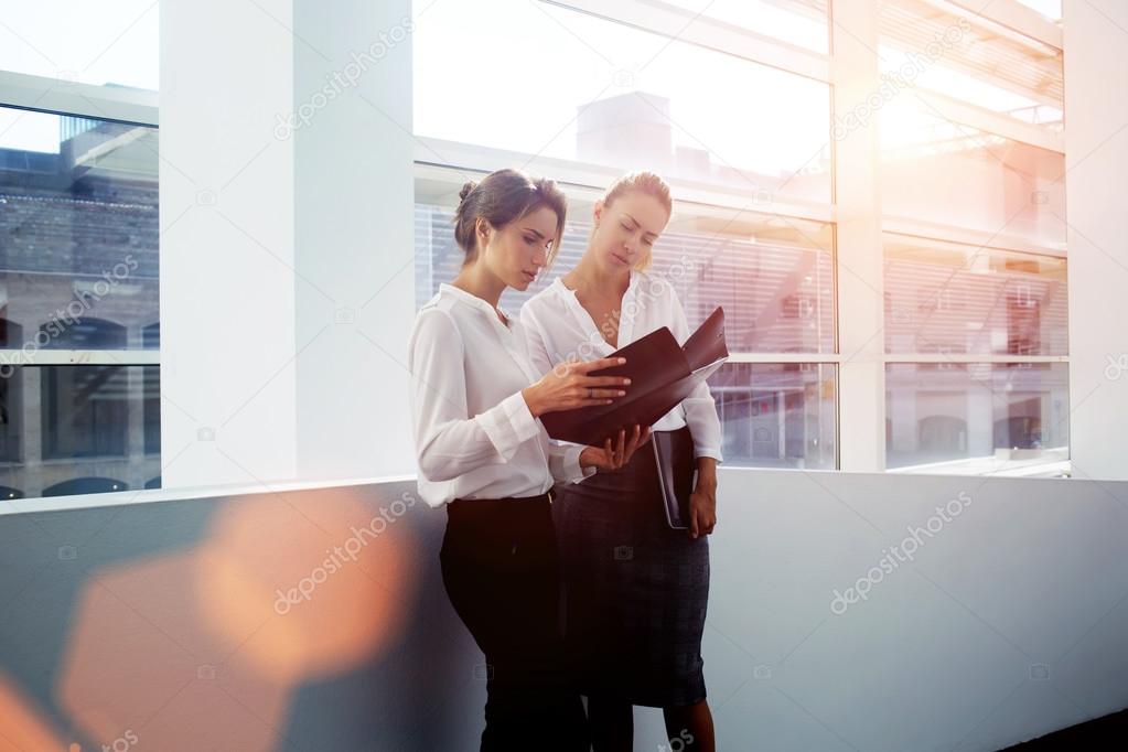 businesswomen considering paper documents