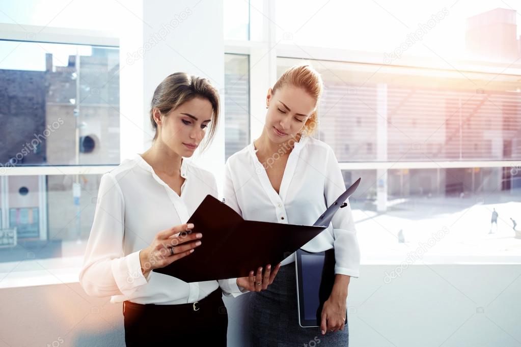 businesswomen considering paper documents