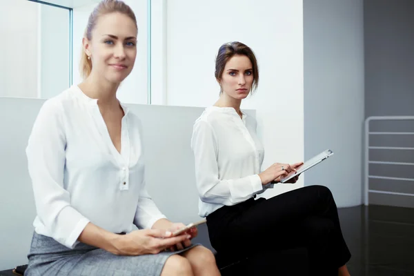 Kvinnliga företagare med digital tablet och cellen telefon — Stockfoto