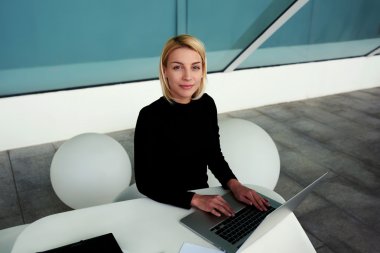 woman posing while working on laptop computer