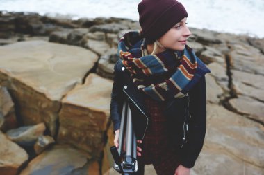woman photographer holding tripod in hand