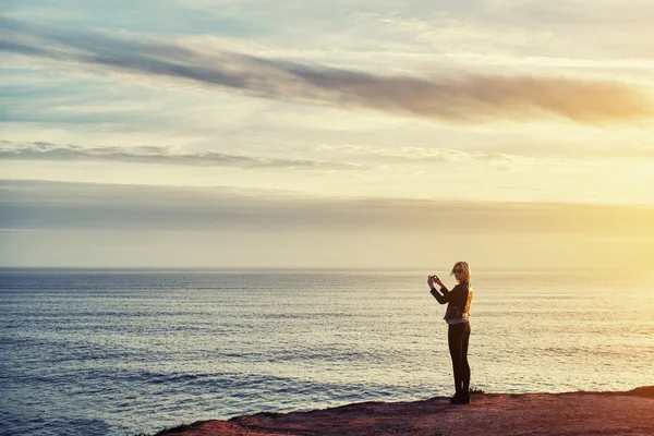 Female taking photo of sea landscape — Stock fotografie