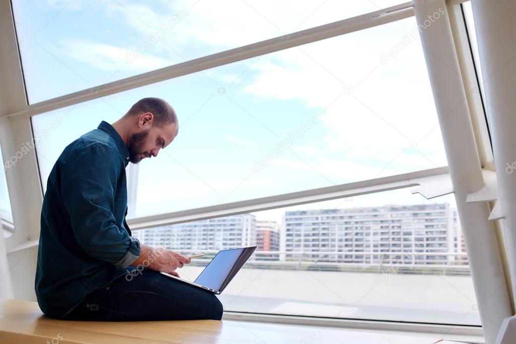 Male designer reading text message