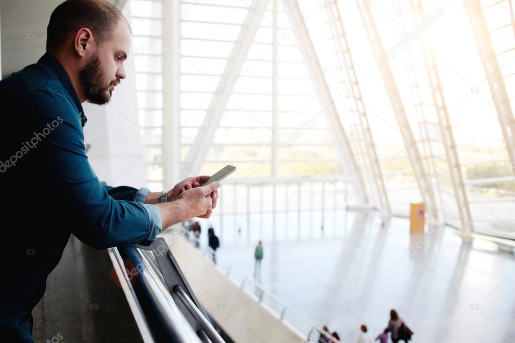 young man standing with mobile phone