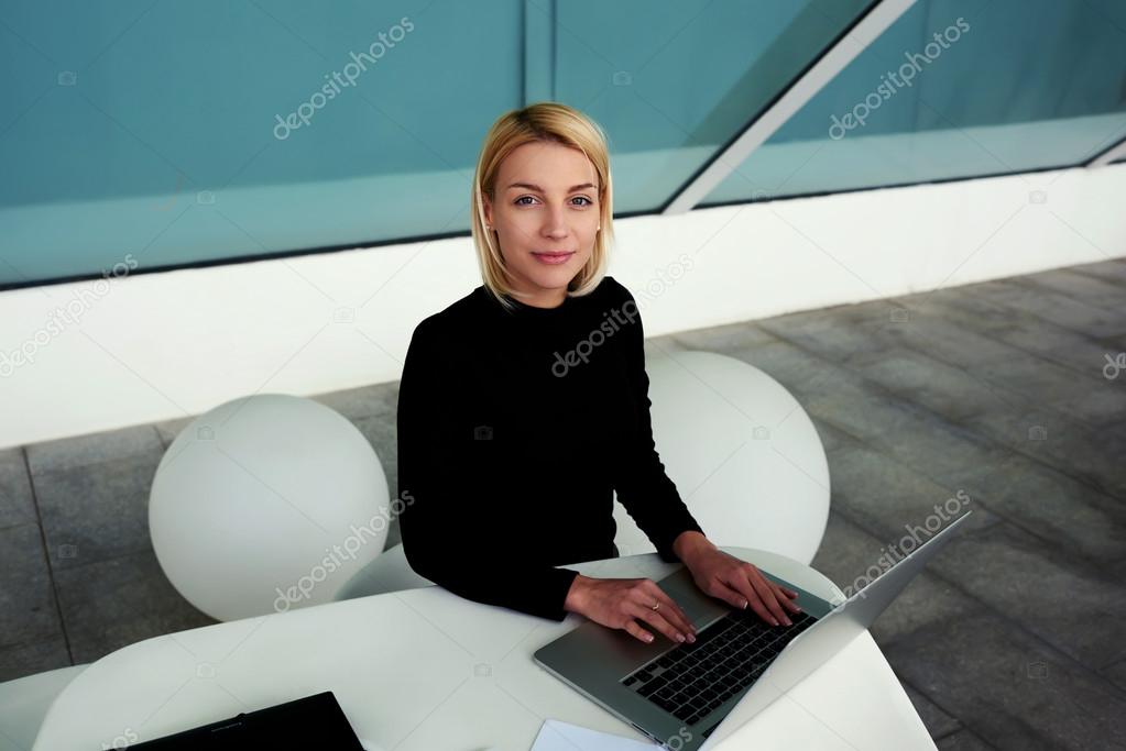 woman posing while working on laptop computer