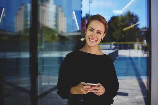Sorrindo empresária de pé com telefone celular — Fotografia de Stock