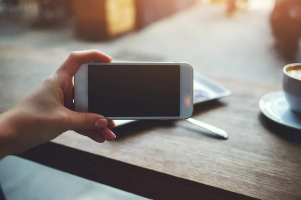 Mano femenina sosteniendo el teléfono móvil — Foto de Stock