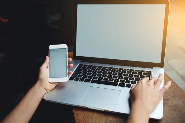 Female hands using mobile phone and laptop — ストック写真