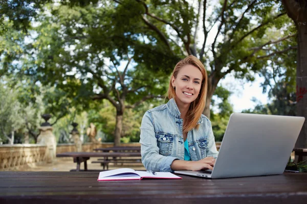 Estudante do sexo feminino sentado com laptop — Fotografia de Stock