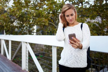 charming woman making photo via smartphone